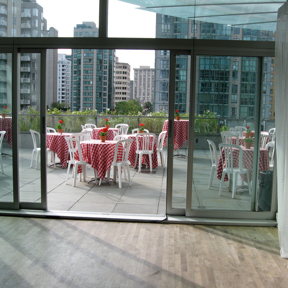 Chairs and tables arranged on the patio of the Scotiabank Dance Centre for a summer event